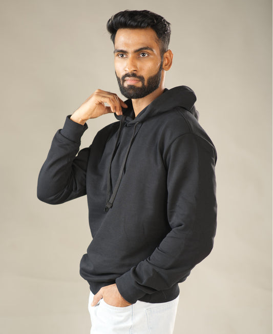 Man wearing a black hoodie against a plain background