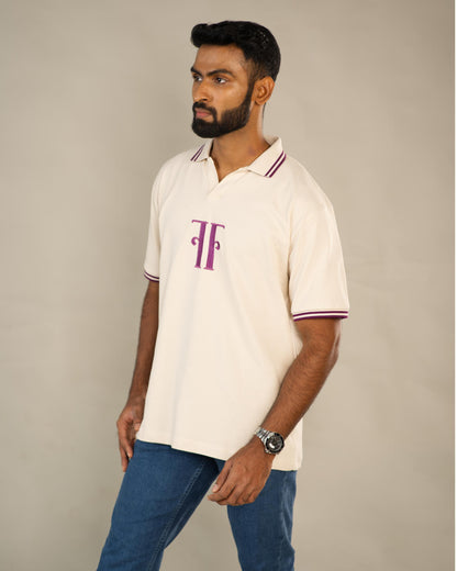 Man wearing a white polo shirt with a logo on a plain background