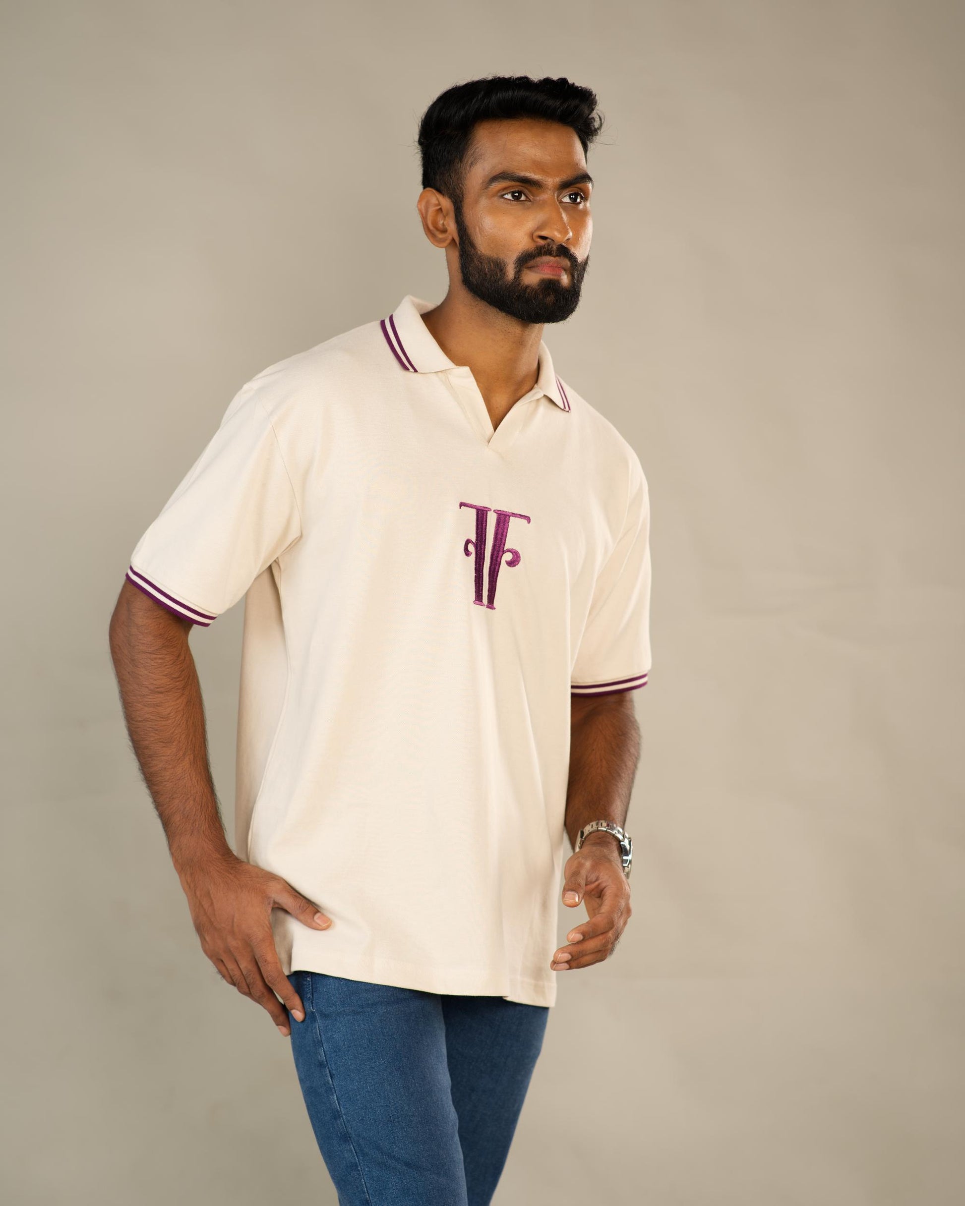 Man wearing a cream polo shirt with a logo on a plain background - Image 4