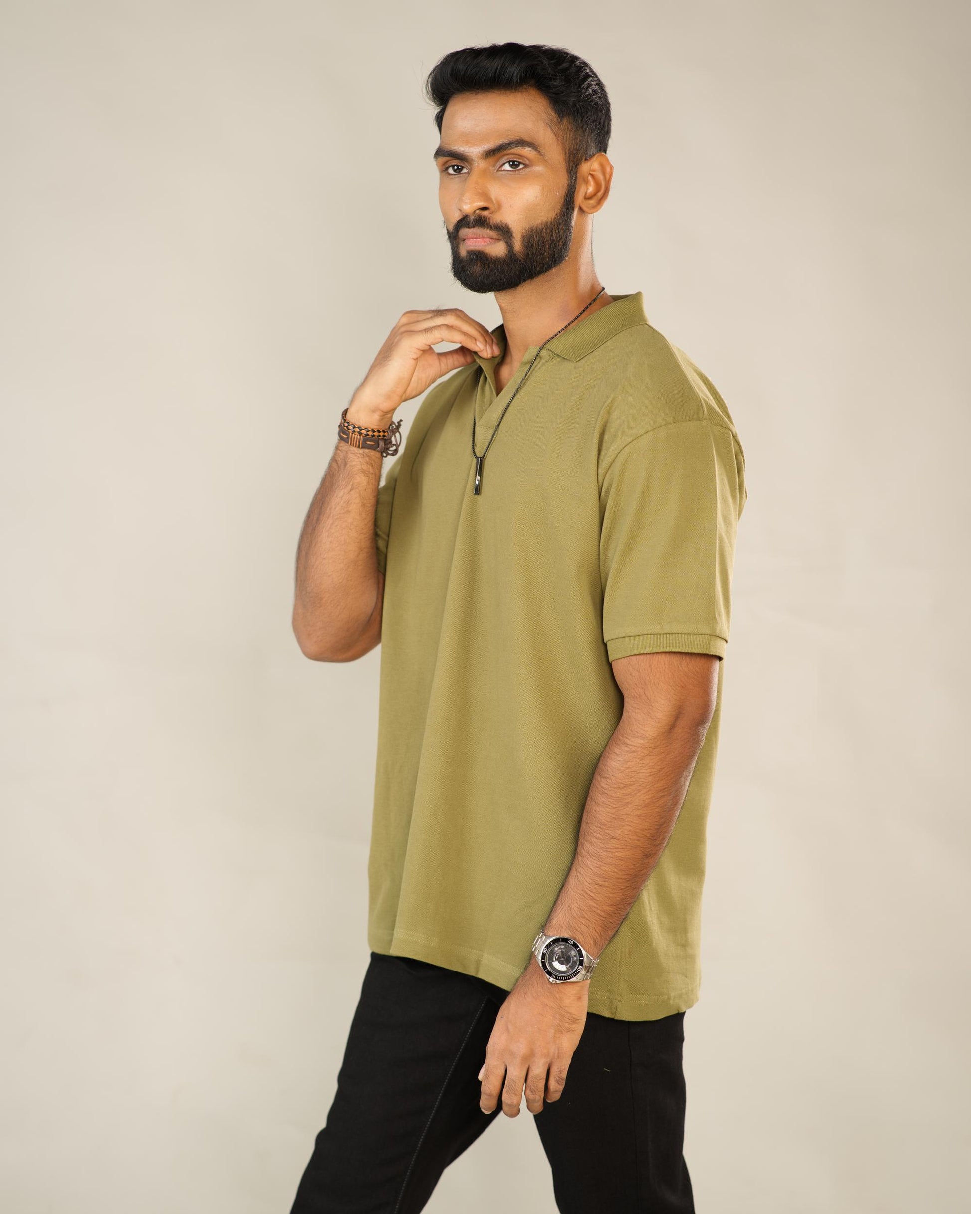 Man wearing an olive green polo shirt against a beige background - Image 2