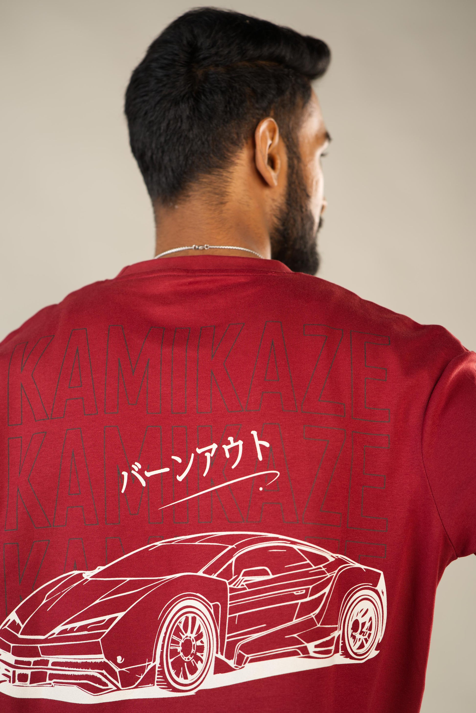 Man wearing a red t-shirt with a white car design and text on the back. - Image 5