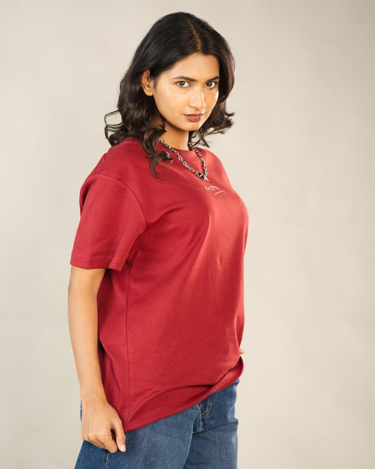 Woman wearing a red shirt with a logo on a plain background