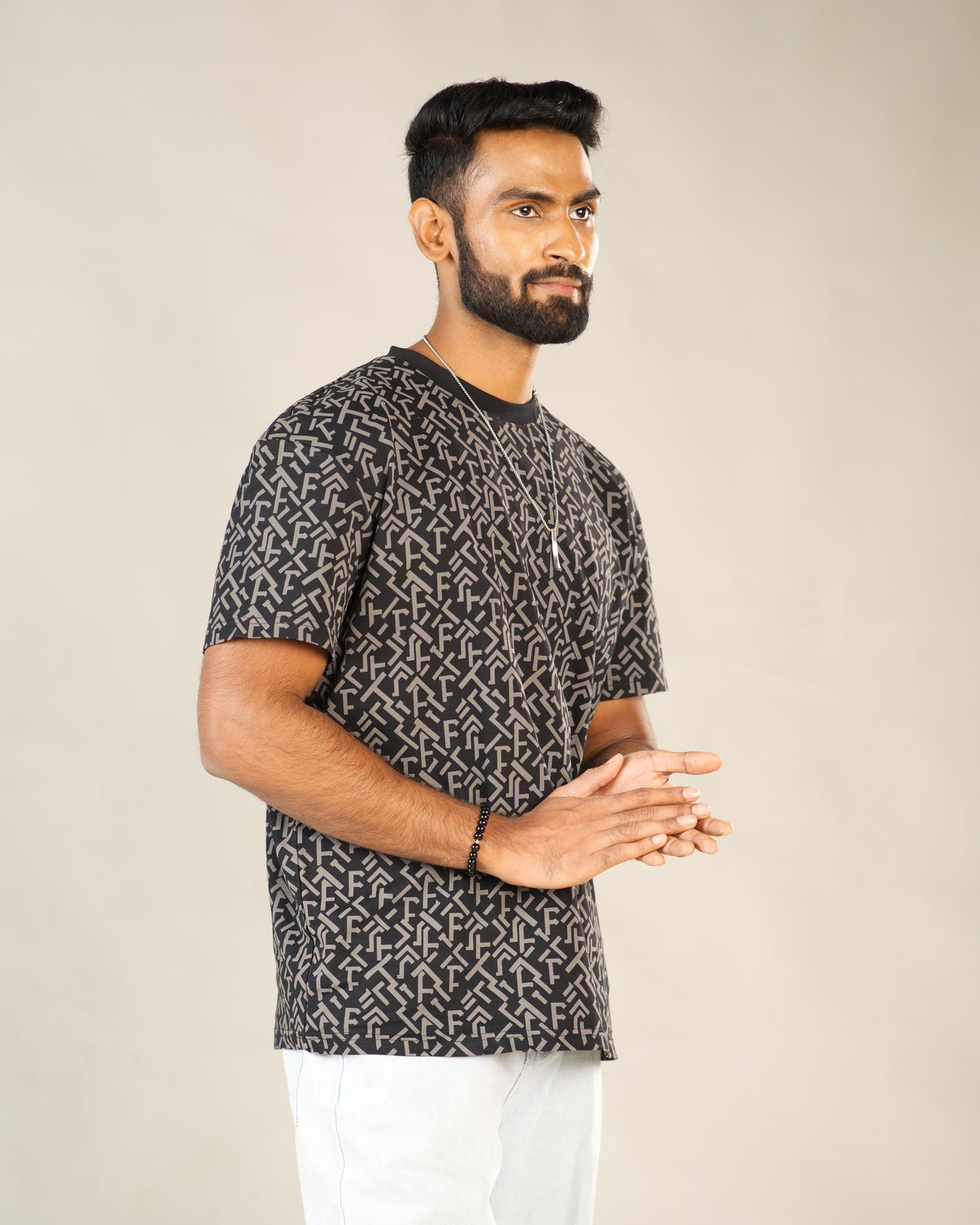 Man wearing a patterned black and gray t-shirt against a plain background