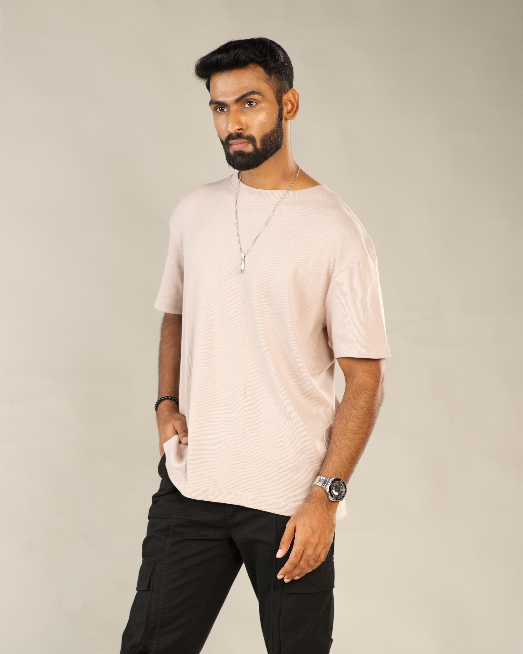 Man wearing a light pink t-shirt and black pants against a plain background - Image 2