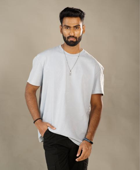 Man wearing a light gray t-shirt and black pants against a beige background - Image 2