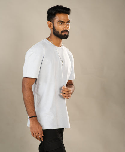 Man wearing a plain white t-shirt against a beige background