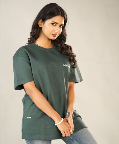 Woman wearing a green t-shirt with text on a plain background