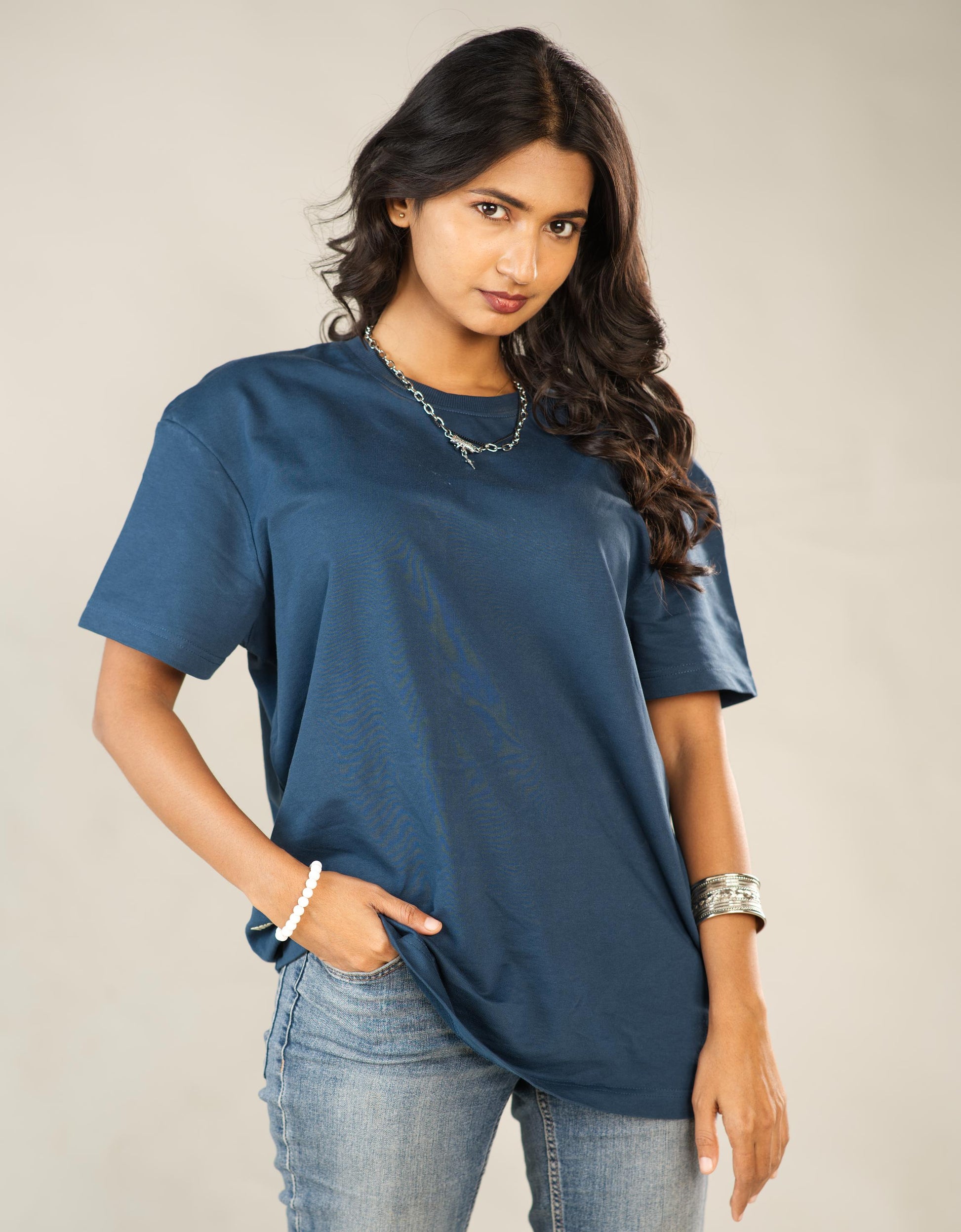 Woman wearing a blue t-shirt and jeans against a plain background - Image 8