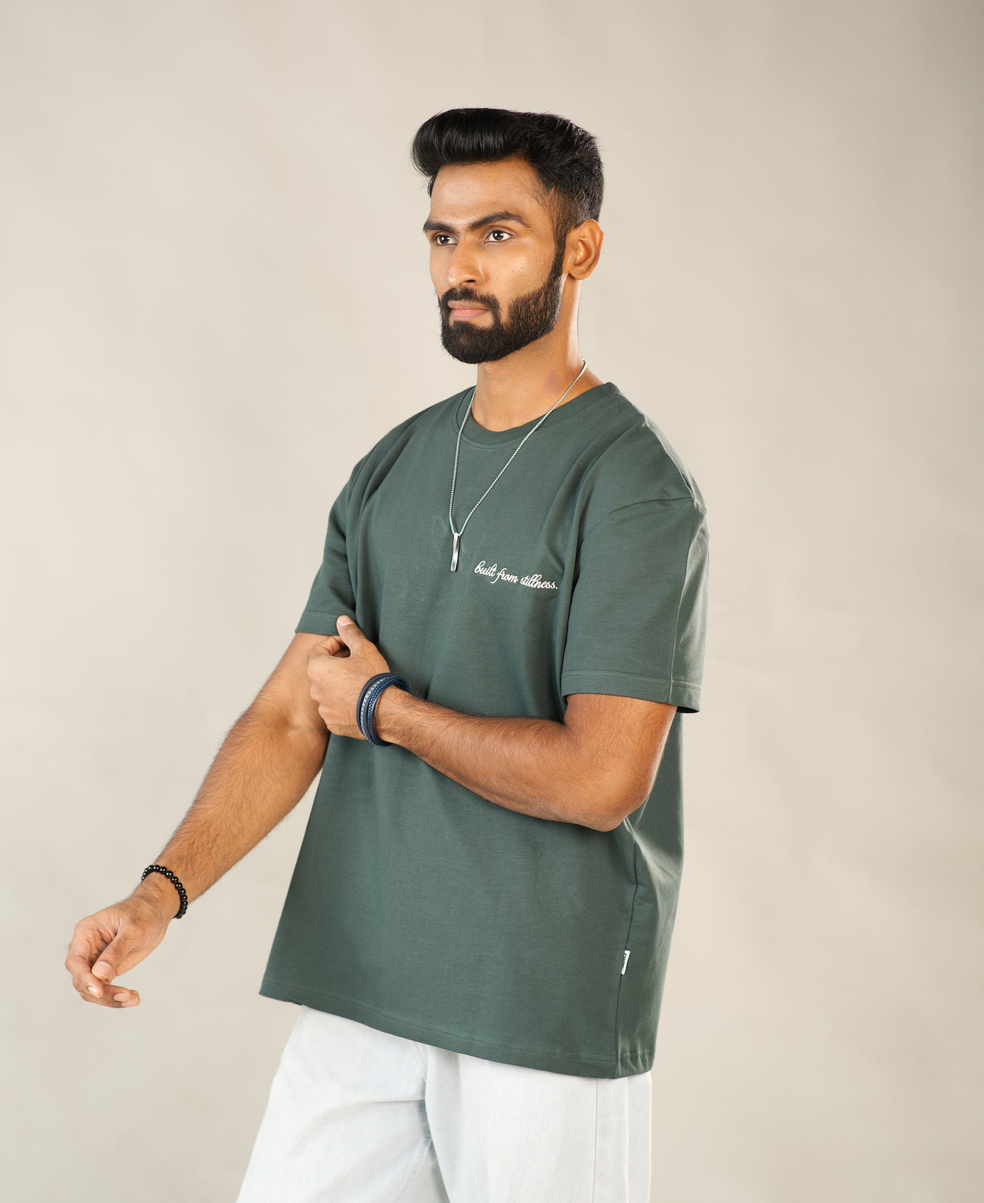 Man wearing a green t-shirt with text on a beige background - Image 6