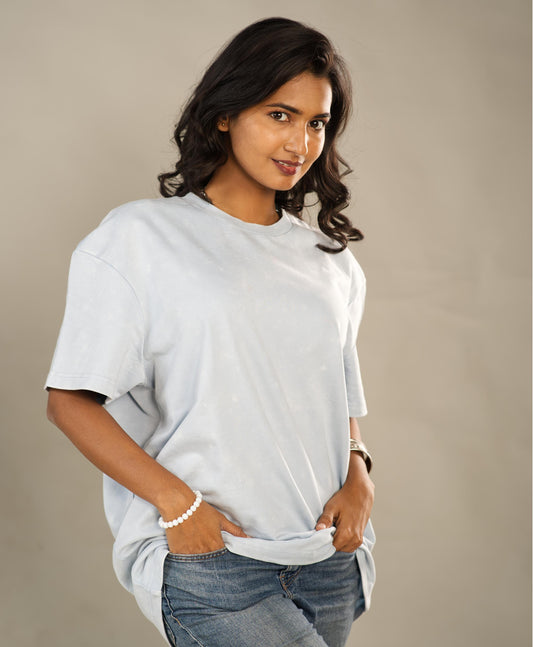 Woman wearing a plain white t-shirt and jeans against a beige background