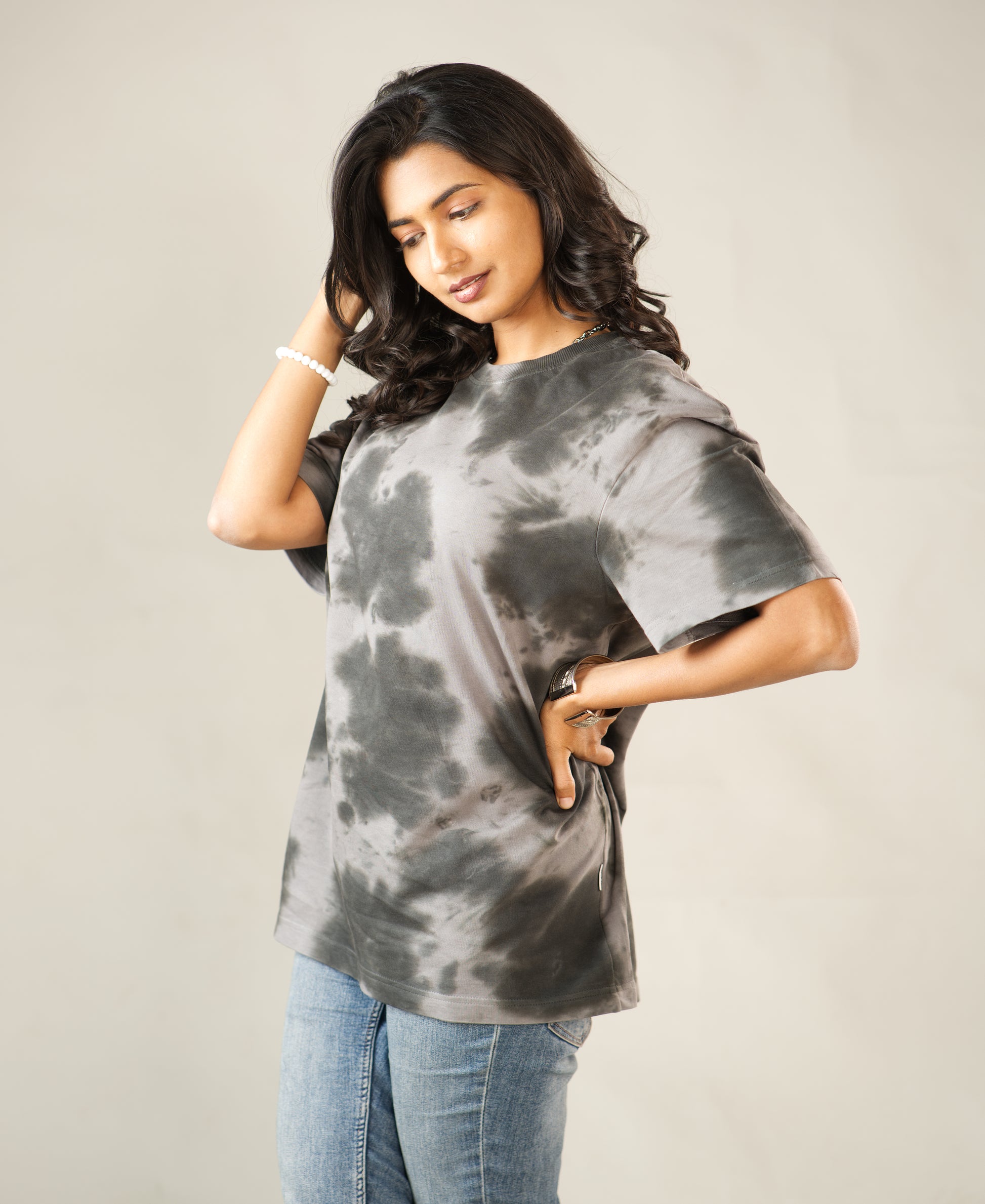 Woman wearing a tie-dye t-shirt against a plain background - Image 7