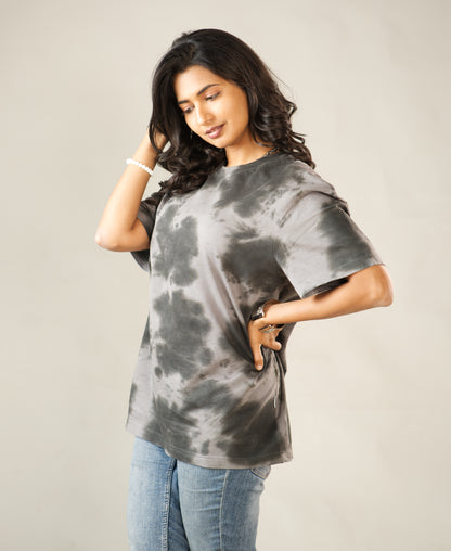 Woman wearing a tie-dye t-shirt against a plain background
