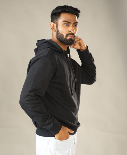 Man wearing a black hoodie against a plain background