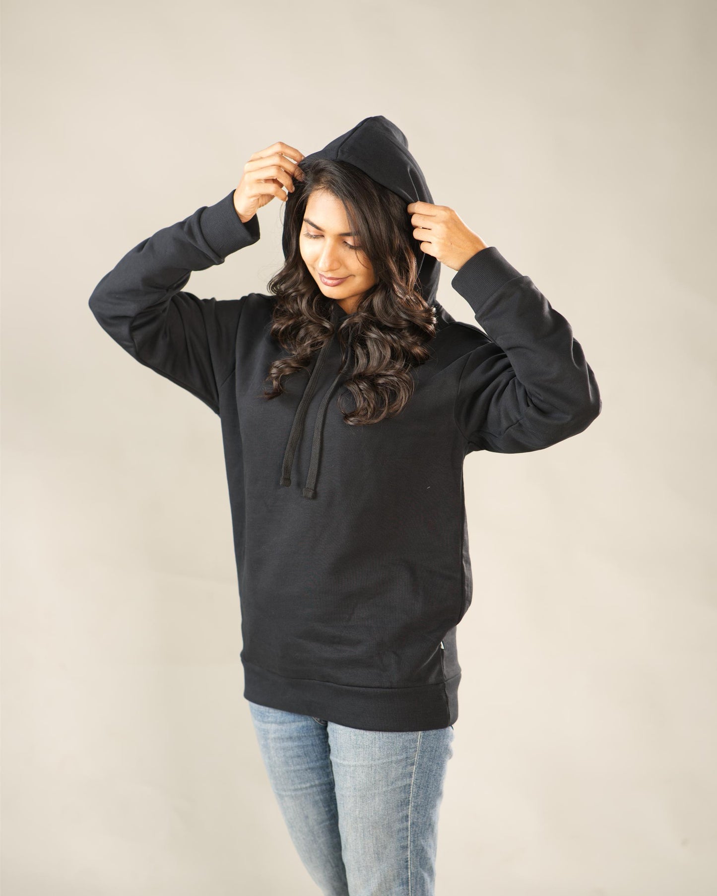 Person wearing a black hoodie against a plain background