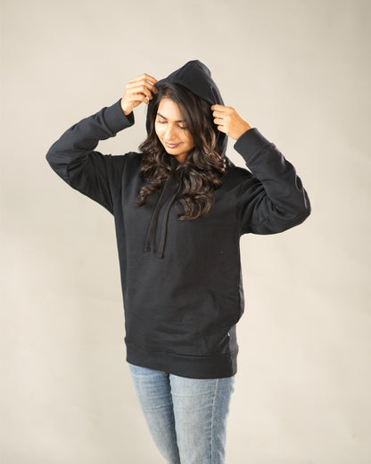 Person wearing a black hoodie against a plain background